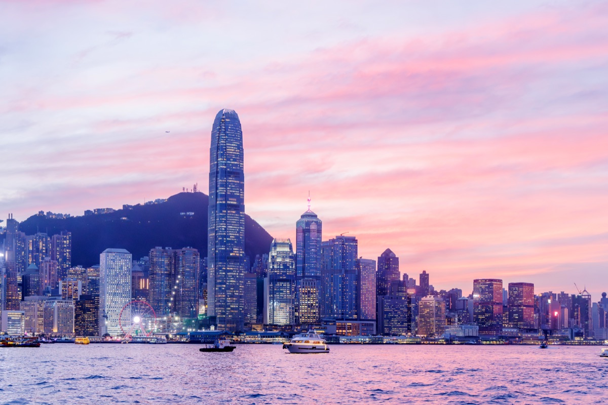 Hong Kong city skyline at sunset with glowing sky and skyscrapers, urban panorama