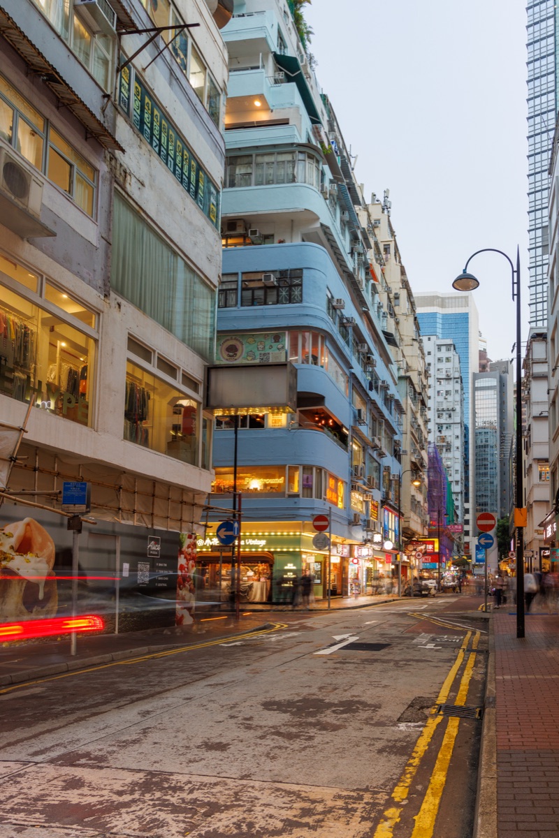 Busy streets of the city in the early evening with people, traffic and bright lights