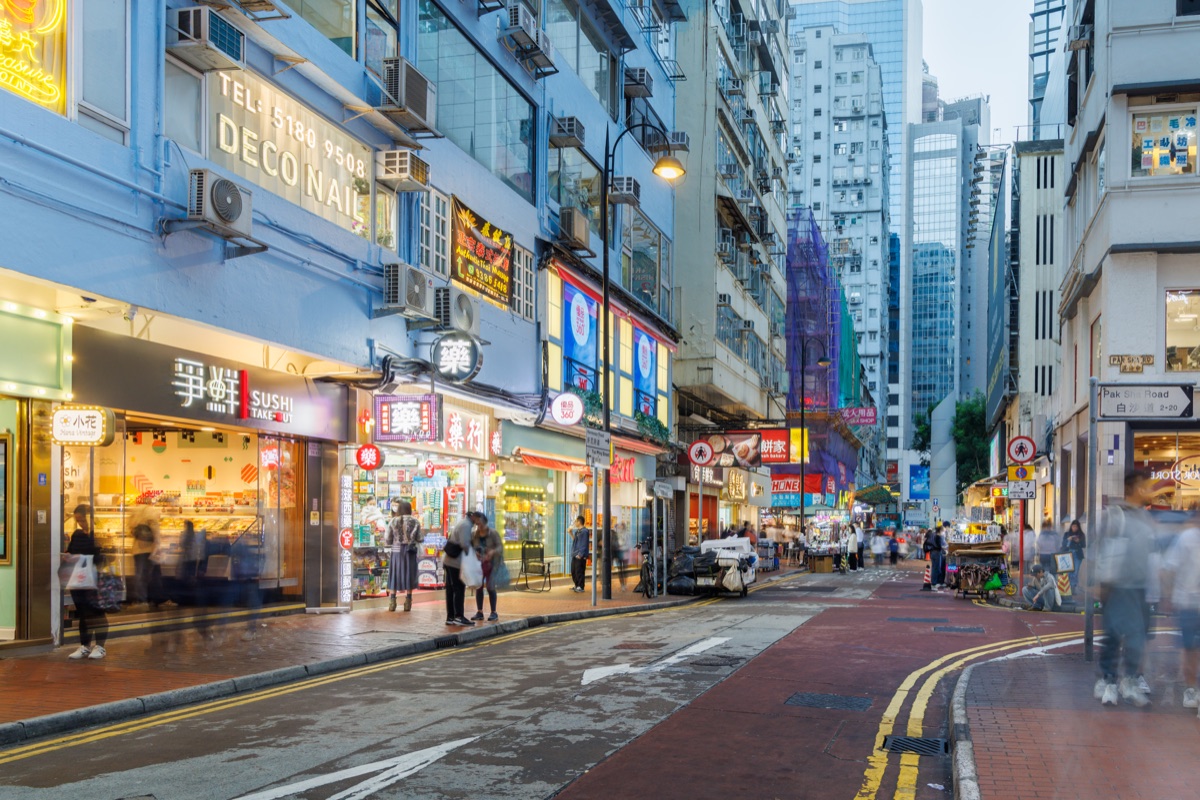 Busy streets of the city in the early evening with people, traffic and bright lights