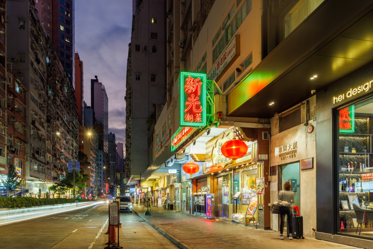Busy streets filled with people and neon lights during evening hours in the city