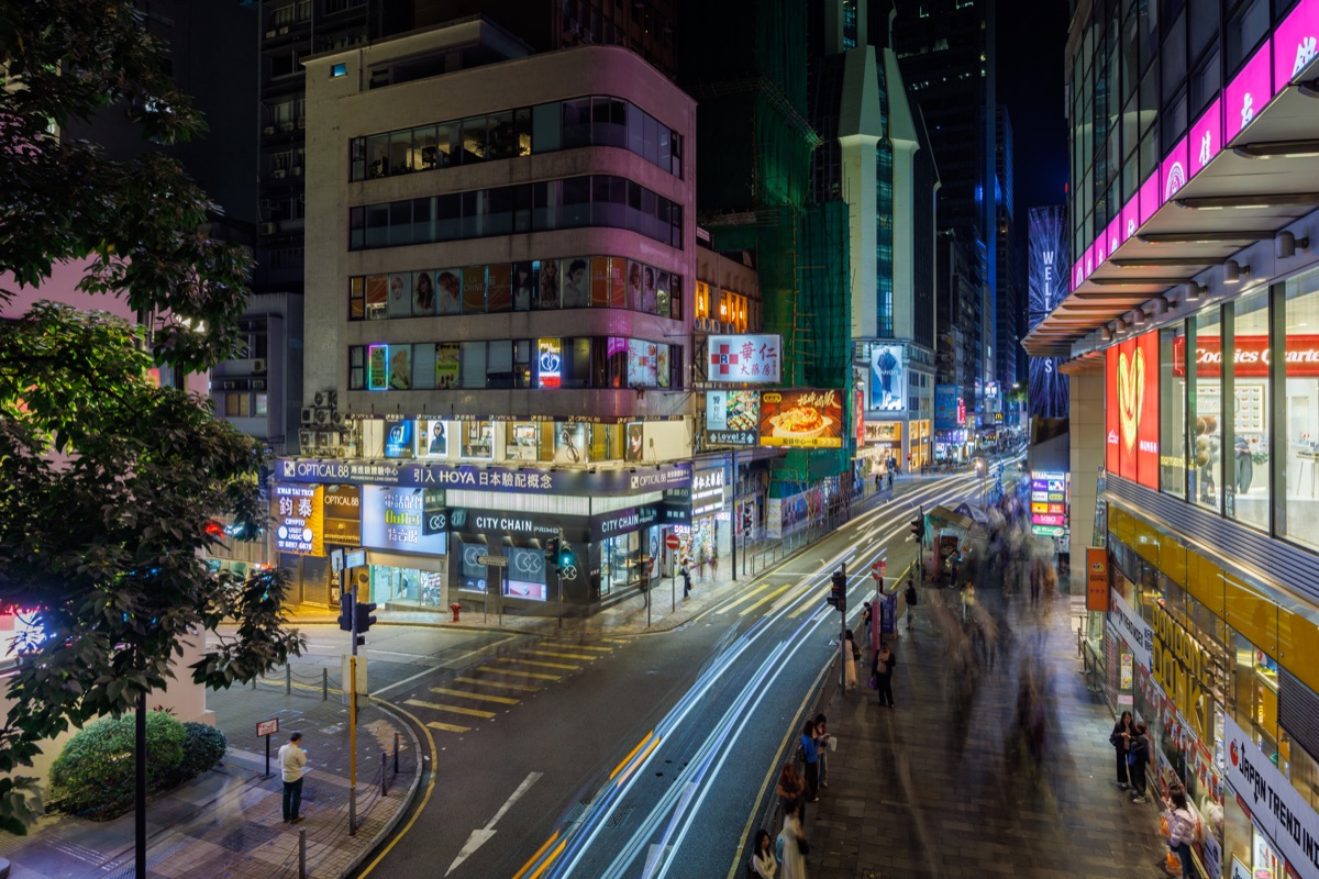 Busy streets filled with people and neon lights during evening hours in the city