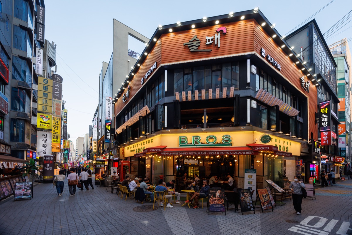 Shops, restaurants and commercial buildings line a busy street in central Seoul.