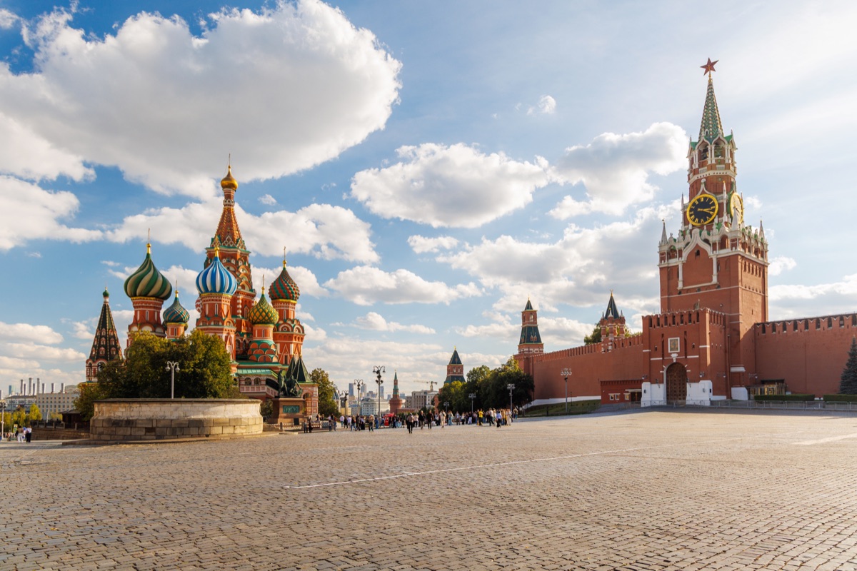Visitors cross the cobblestones of Red Square between Saint Basil's Cathedral and the Kremlin's Spasskaya Tower. Moscow, Russia