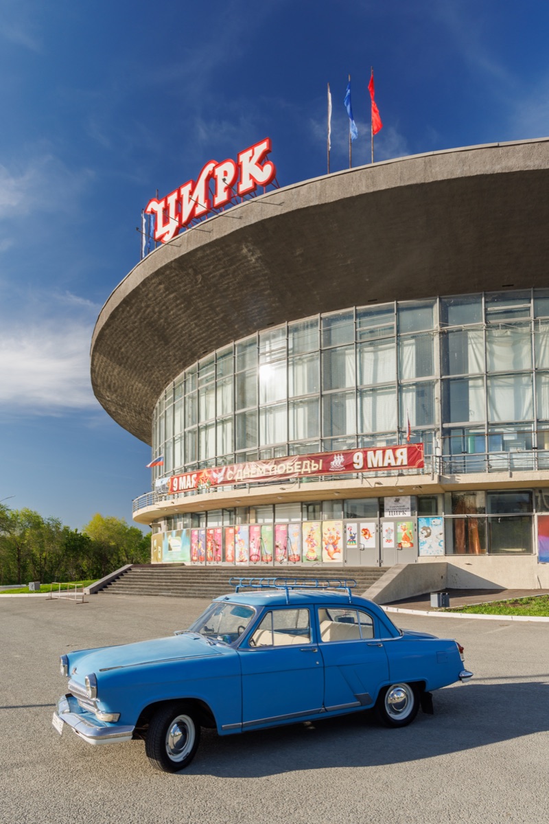 Samara State Circus building with vintage Soviet car parked in front on sunny spring day