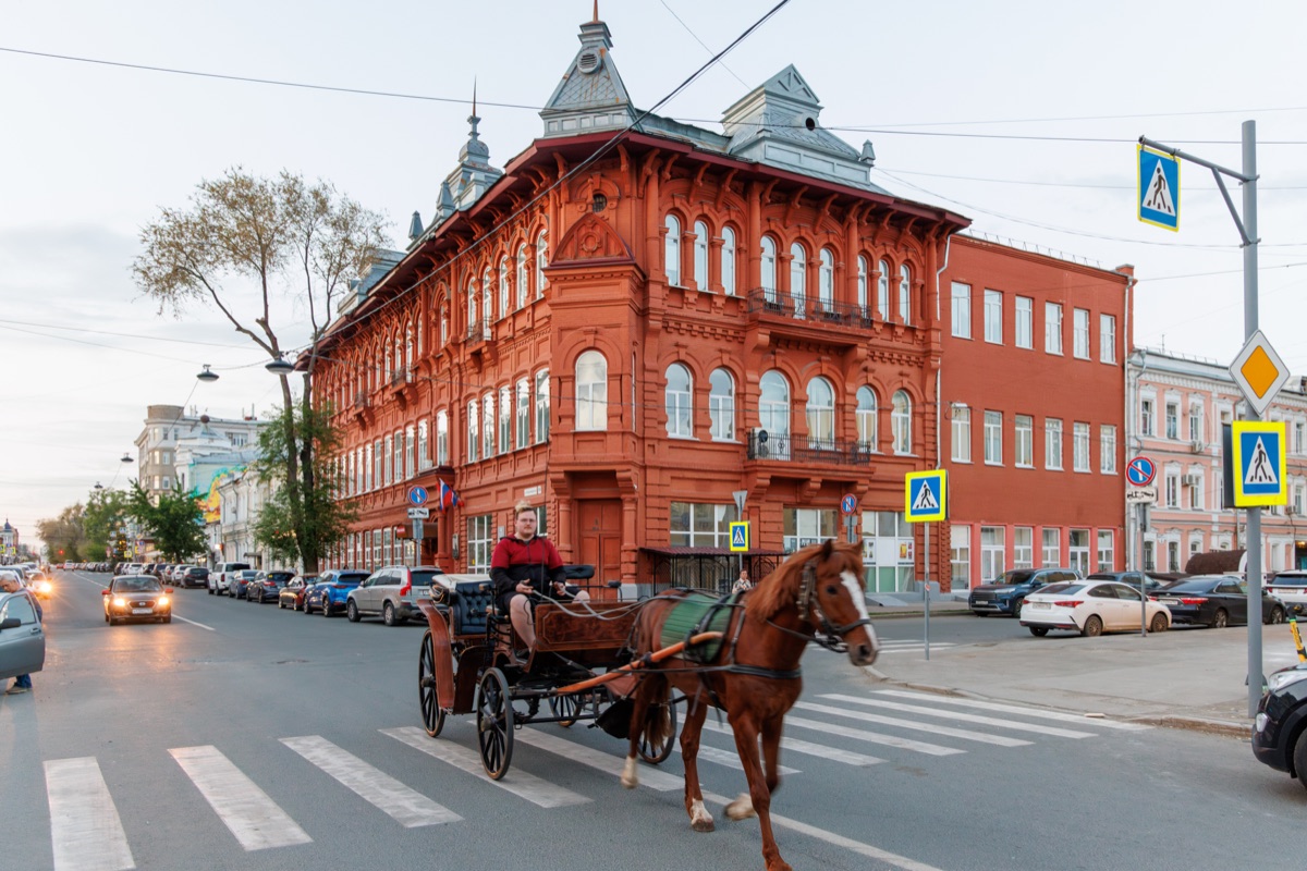 Red brick historic building with horse carriage on city street in Samara center