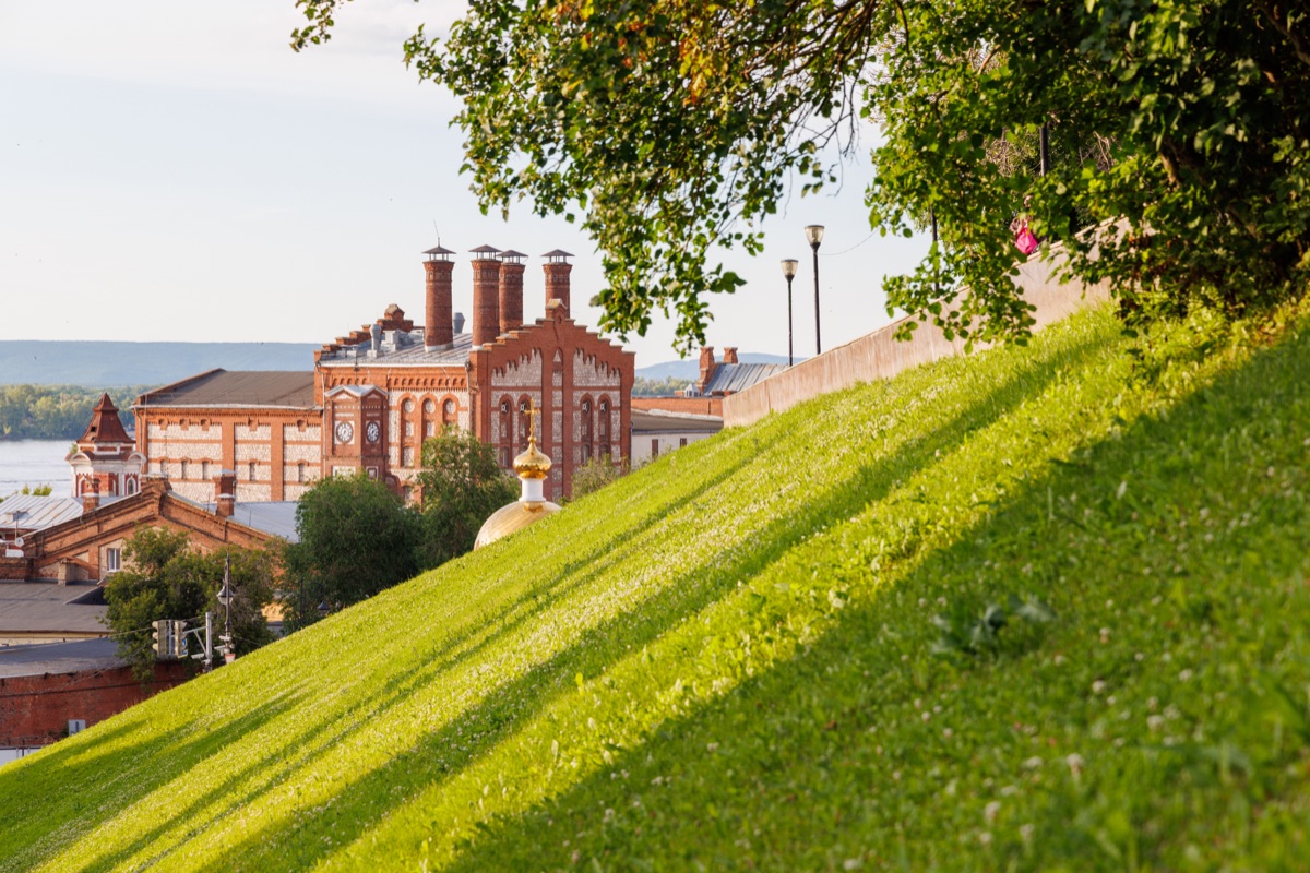 Historic Zhiguli Brewery building viewed above a green hillside on a sunny summer day in Samara, Russia. One of the city's best-known architectural and industrial landmarks.