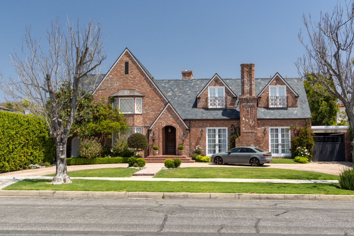 Suburban street with houses in the Los Angeles area, lined with trees under a sunny sky