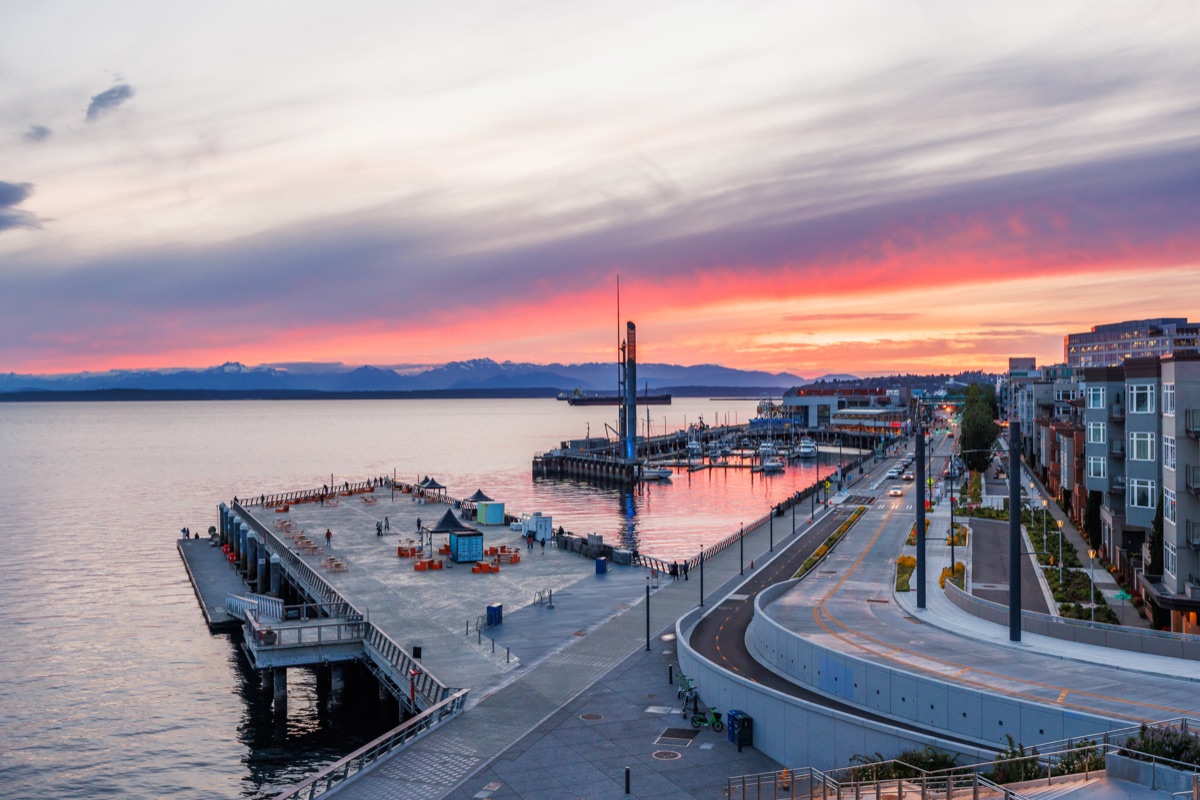 Seattle skyline during sunset with vibrant sky colors and city lights starting to glow